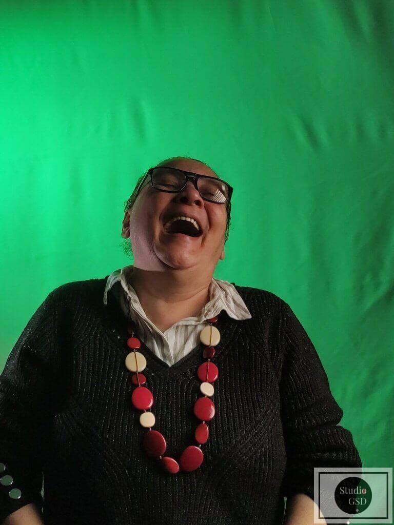 Cathy devant un font vert, et qui connait un fou rire