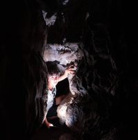 Ado qui sort d'un trou dans une grotte