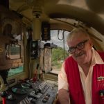 Reportage d'entreprise conducteur de train en gilet rouge qui présente ses installations