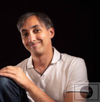 Sébastien DUCHER, assis avec une jambe pliée, qui souris