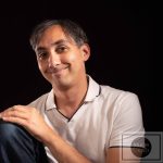 Sébastien DUCHER, assis avec une jambe pliée, qui souris