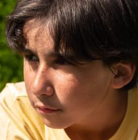 Garçon en tee-shirt jaune qui regarde au loin
