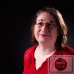Portrait Corporate 16/9ème pour projet numérique et impression photographie corporate de femme au tee-shirt rouge et avec des lunettes