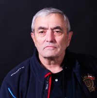 Homme habillé en bleu marine portant ses lunettes à la main